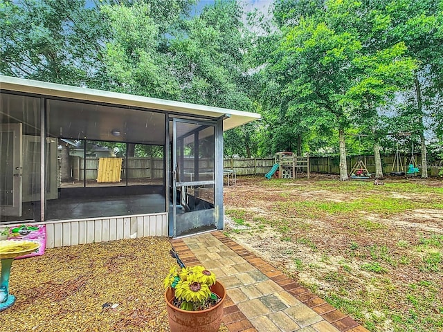 12181 SE 87th Ct, Belleview, FL 34420 - fenced backyard with a sunroom and a playground