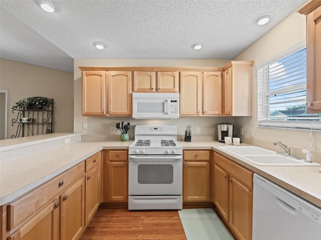 2369 Five Forks Trl, The Villages, FL 32162 - kitchen with white appliances, a textured ceiling, light brown cabinetry, light countertops, and light wood-style flooring