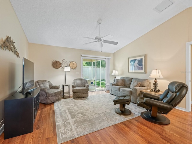 2369 Five Forks Trl, The Villages, FL 32162 - living room with vaulted ceiling, wood finished floors, a ceiling fan, and a textured ceiling