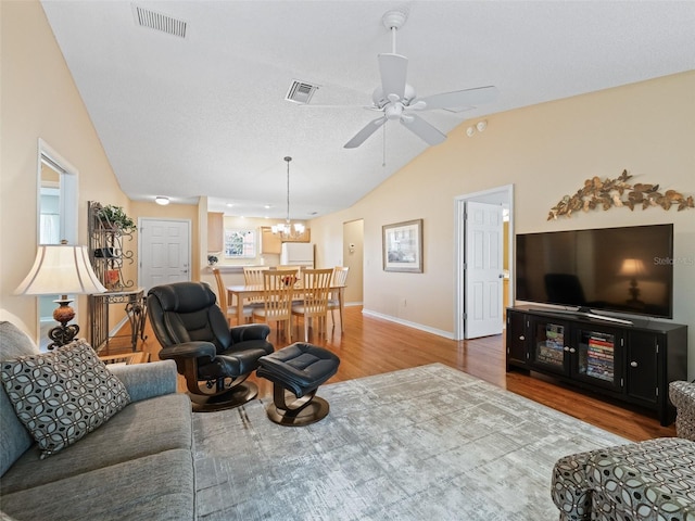 2369 Five Forks Trl, The Villages, FL 32162 - living room featuring lofted ceiling, wood finished floors, ceiling fan, and a chandelier