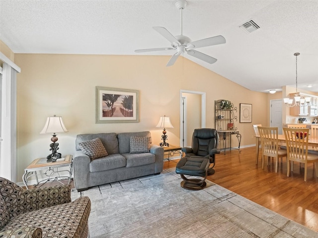 2369 Five Forks Trl, The Villages, FL 32162 - living area with wood finished floors, vaulted ceiling, a chandelier, a ceiling fan, and a textured ceiling