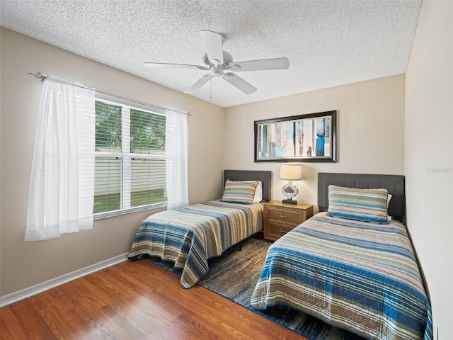 2369 Five Forks Trl, The Villages, FL 32162 - bedroom featuring wood finished floors, a textured ceiling, and ceiling fan