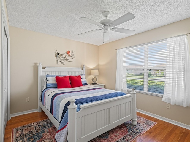 2369 Five Forks Trl, The Villages, FL 32162 - bedroom featuring a textured ceiling, wood finished floors, and a ceiling fan