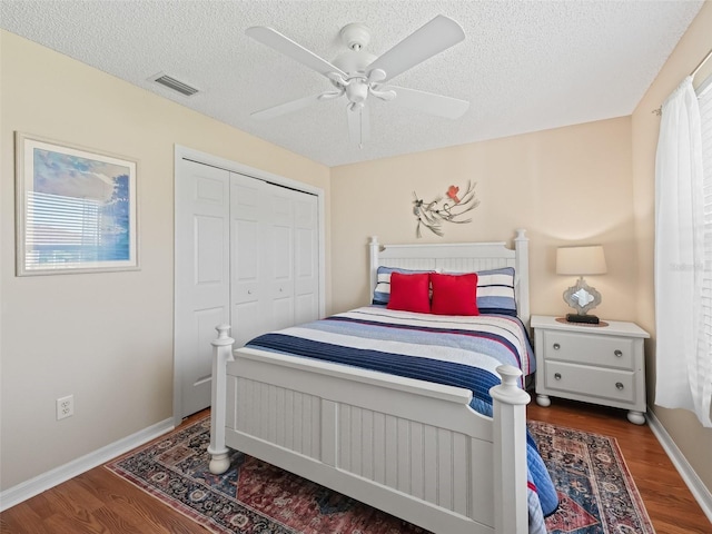 2369 Five Forks Trl, The Villages, FL 32162 - bedroom with wood finished floors, a textured ceiling, a closet, ceiling fan, and multiple windows