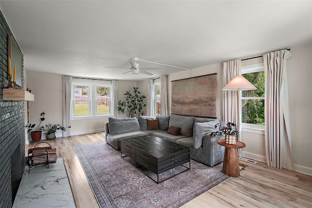 126 E Beach St, Groveland, FL 34736 - living area featuring ceiling fan, a fireplace, and light wood-style floors