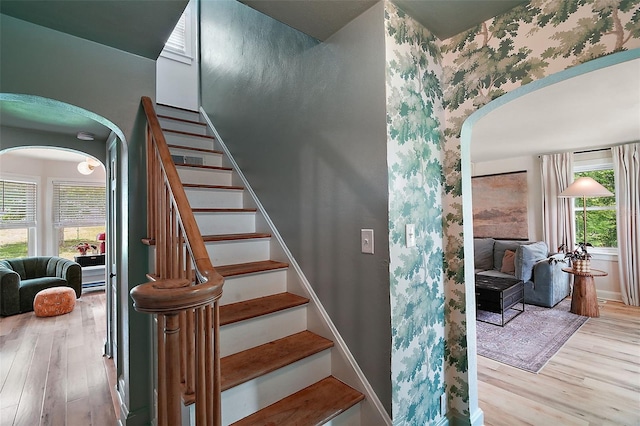 126 E Beach St, Groveland, FL 34736 - stairs with arched walkways, wallpapered walls, wood finished floors, and healthy amount of natural light