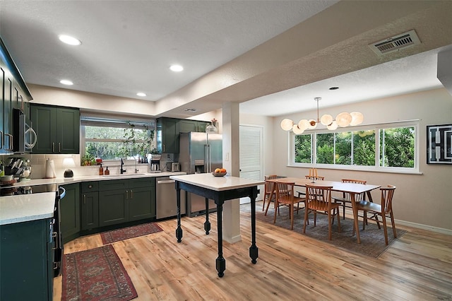 126 E Beach St, Groveland, FL 34736 - kitchen featuring appliances with stainless steel finishes, green cabinets, light countertops, light wood-style floors, and recessed lighting