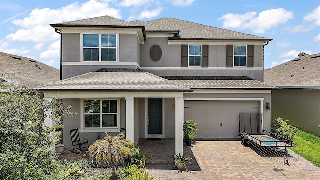 9153 Carmela Ave, Davenport, FL 33897 - traditional home with an attached garage, decorative driveway, stucco siding, and a shingled roof