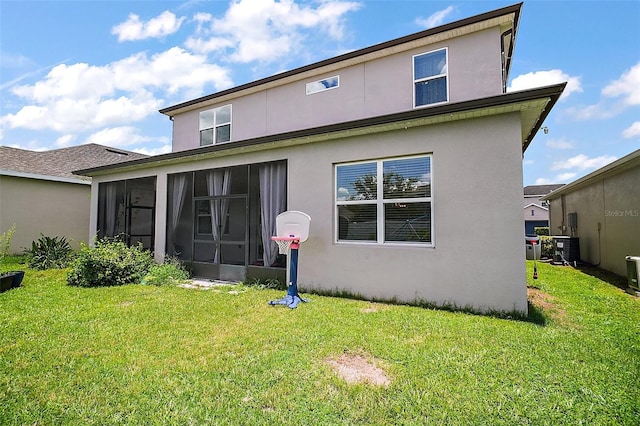 9153 Carmela Ave, Davenport, FL 33897 - back of house with a sunroom, stucco siding, and a yard