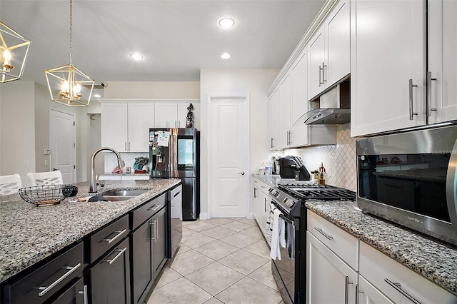 9153 Carmela Ave, Davenport, FL 33897 - kitchen featuring gas stove, refrigerator with ice dispenser, stainless steel microwave, a chandelier, and under cabinet range hood
