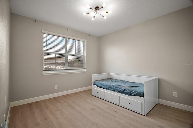 9153 Carmela Ave, Davenport, FL 33897 - unfurnished bedroom featuring a chandelier and wood finished floors