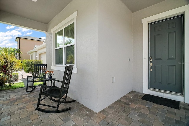 9153 Carmela Ave, Davenport, FL 33897 - view of exterior entry featuring stucco siding and covered porch