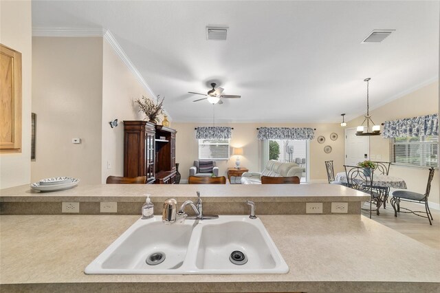 2237 Jetta Way, The Villages, FL 32162 - kitchen featuring crown molding, a ceiling fan, hanging light fixtures, light countertops, and a fireplace