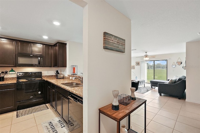1940 Piedmont Ct, Mascotte, FL 34753 - kitchen with black appliances, light tile patterned floors, light stone counters, open floor plan, and dark brown cabinets