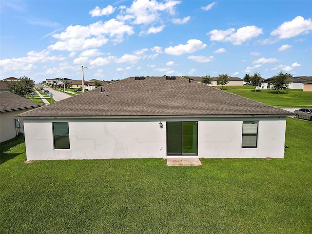 1940 Piedmont Ct, Mascotte, FL 34753 - back of property with a shingled roof, a residential view, and a lawn