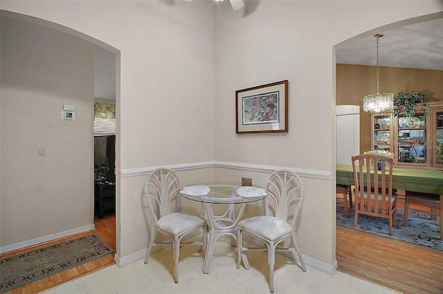 1007 Diego Ct, The Villages, FL 32159 - dining area with arched walkways, wood finished floors, a chandelier, and a ceiling fan