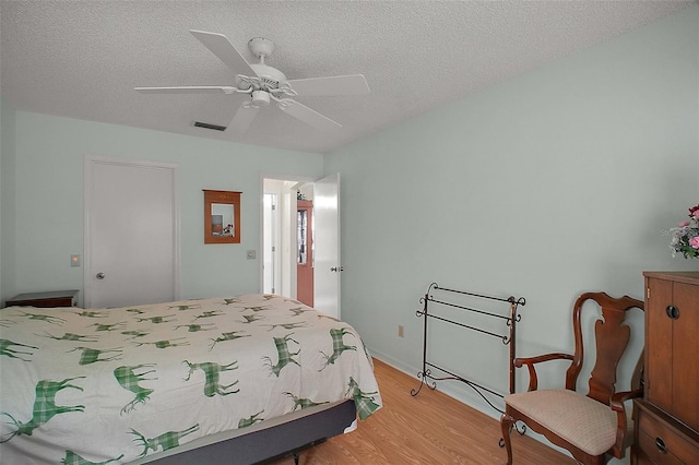 1007 Diego Ct, The Villages, FL 32159 - bedroom with light wood finished floors, a textured ceiling, and a ceiling fan