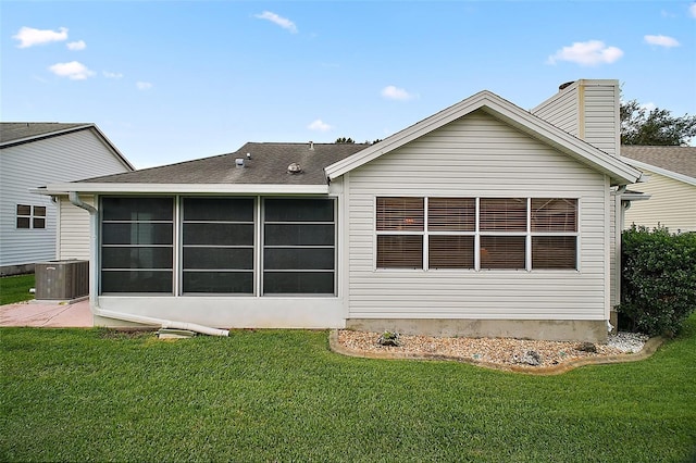 1007 Diego Ct, The Villages, FL 32159 - back of property featuring a lawn, a sunroom, a chimney, and roof with shingles