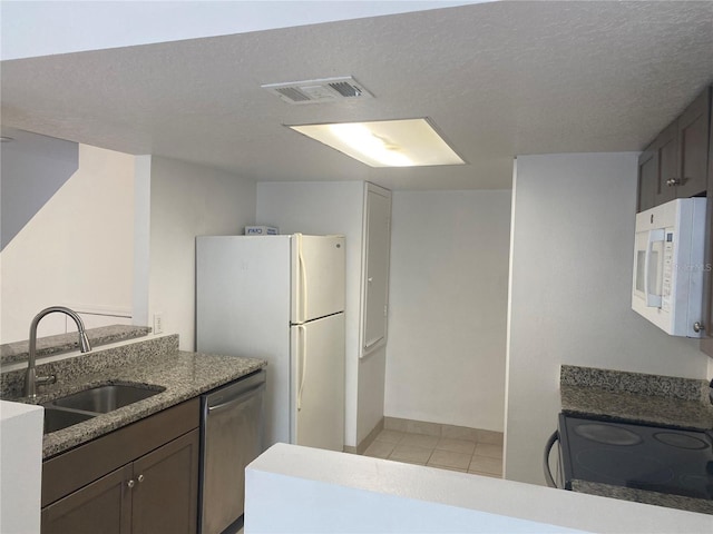 624 Australian Way, Davenport, FL 33897 - kitchen with white appliances, light tile patterned floors, stone counters, and a textured ceiling