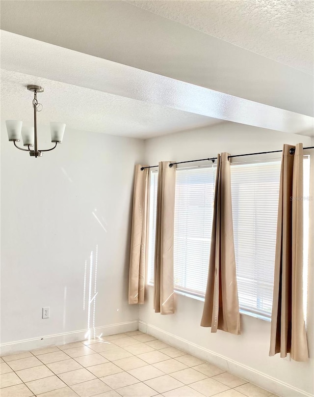 624 Australian Way, Davenport, FL 33897 - empty room featuring a chandelier, light tile patterned flooring, a textured ceiling, and healthy amount of natural light