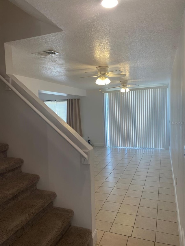 624 Australian Way, Davenport, FL 33897 - staircase with a textured ceiling, tile patterned floors, and a ceiling fan