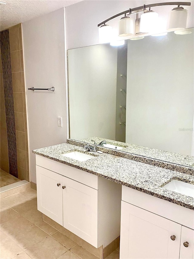 624 Australian Way, Davenport, FL 33897 - full bath featuring double vanity, tile patterned flooring, a textured ceiling, and tiled shower