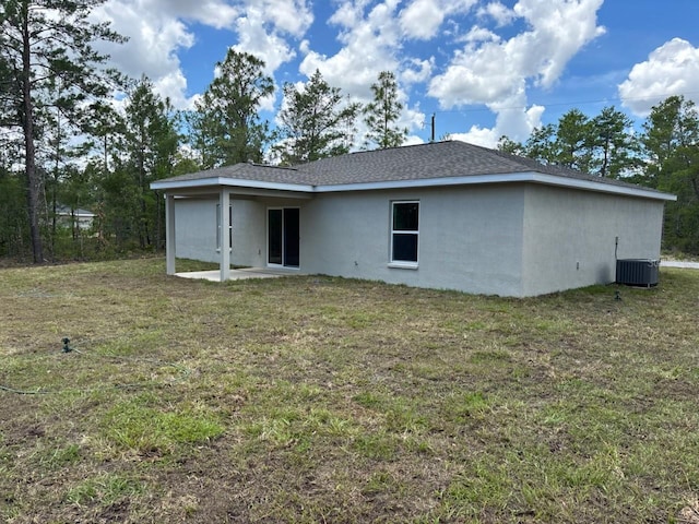 6769 N Waterman Dr, Dunnellon, FL 34433 - rear view of house with stucco siding, a lawn, and a patio area