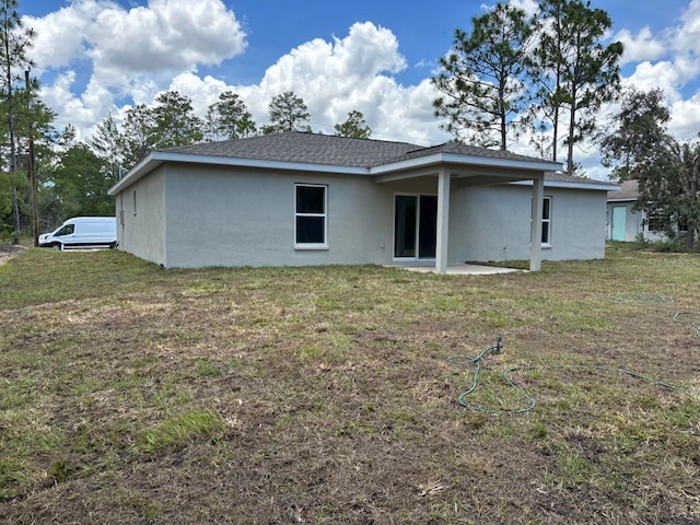 6769 N Waterman Dr, Dunnellon, FL 34433 - rear view of property featuring stucco siding and a lawn