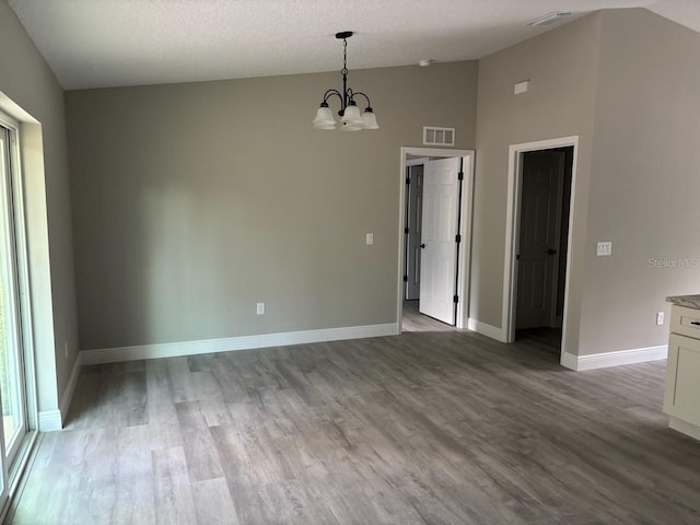 6769 N Waterman Dr, Dunnellon, FL 34433 - unfurnished dining area featuring a chandelier, wood finished floors, and high vaulted ceiling