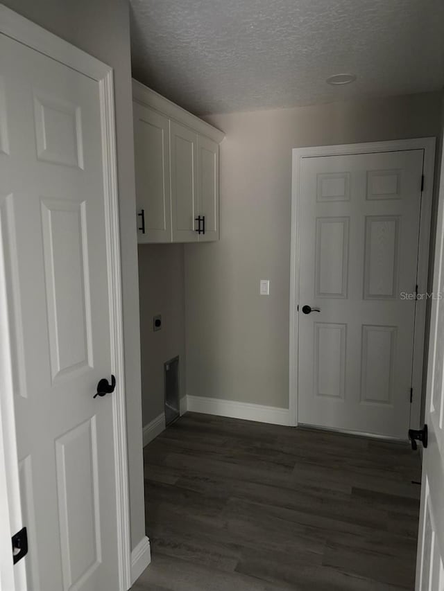 6769 N Waterman Dr, Dunnellon, FL 34433 - laundry area with hookup for an electric dryer, dark wood-style flooring, a textured ceiling, and cabinet space