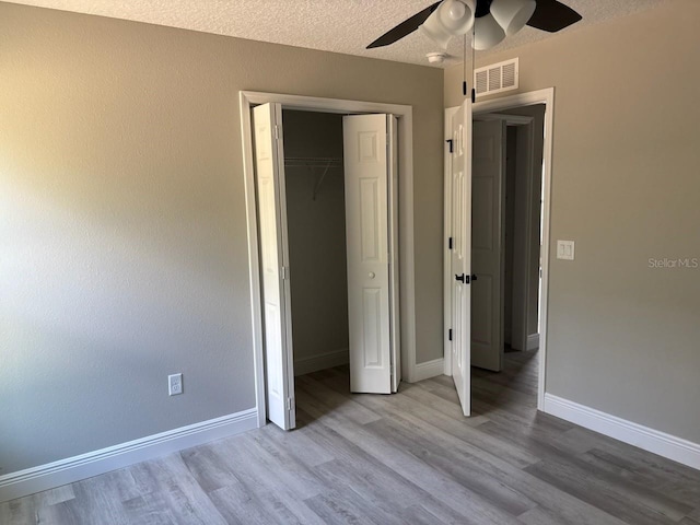 6769 N Waterman Dr, Dunnellon, FL 34433 - unfurnished bedroom featuring wood finished floors, a closet, a textured ceiling, and ceiling fan