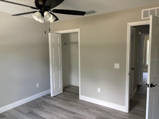 6769 N Waterman Dr, Dunnellon, FL 34433 - unfurnished bedroom featuring wood finished floors, a closet, a textured ceiling, and a ceiling fan