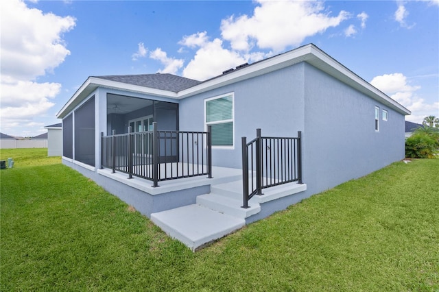 6949 Minchew Cir, The Villages, FL 34762 - rear view of property with a yard, a sunroom, stucco siding, and a shingled roof