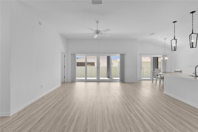 6949 Minchew Cir, The Villages, FL 34762 - unfurnished living room featuring lofted ceiling, healthy amount of natural light, and light wood-style flooring