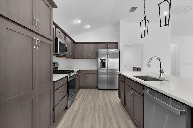 6949 Minchew Cir, The Villages, FL 34762 - kitchen featuring appliances with stainless steel finishes, lofted ceiling, light countertops, dark brown cabinets, and hanging light fixtures