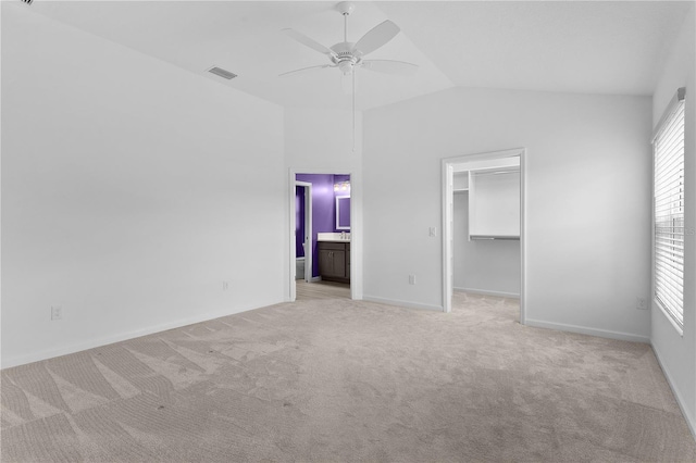 6949 Minchew Cir, The Villages, FL 34762 - unfurnished bedroom featuring light carpet, a spacious closet, lofted ceiling, connected bathroom, and a ceiling fan