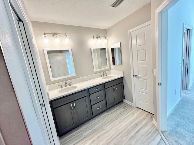 6949 Minchew Cir, The Villages, FL 34762 - full bathroom featuring double vanity, a textured ceiling, and wood finished floors