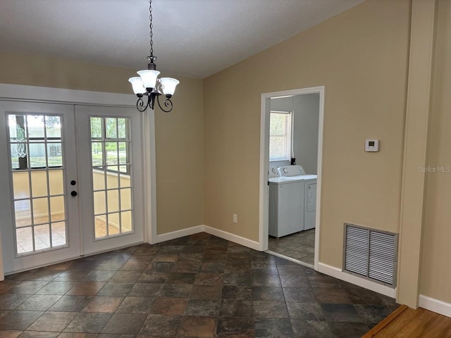 7186 N Whippoorwill Ter, Hernando, FL 34442 - unfurnished dining area featuring independent washer and dryer, french doors, a chandelier, lofted ceiling, and dark stone finish floors