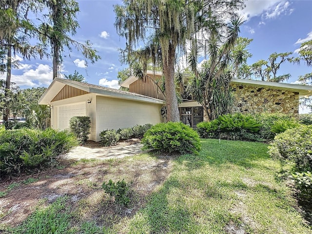 11401 Cypress Dr, Clermont, FL 34711 - view of side of property with an attached garage, concrete block siding, and a yard