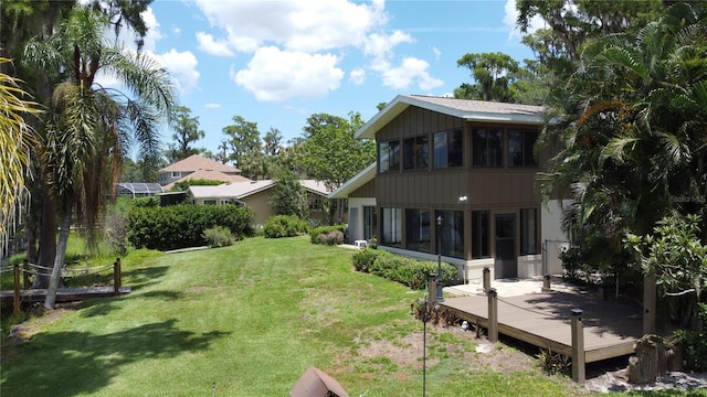 11401 Cypress Dr, Clermont, FL 34711 - rear view of property featuring a sunroom, a wooden deck, and a yard