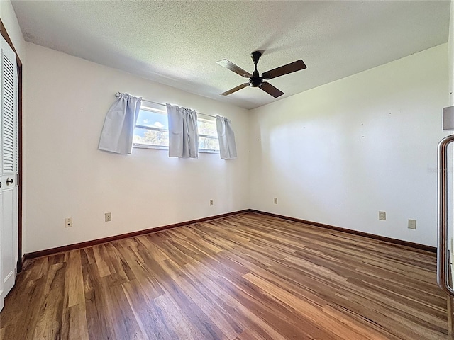 11401 Cypress Dr, Clermont, FL 34711 - unfurnished bedroom with wood finished floors, a textured ceiling, and a ceiling fan