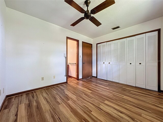 11401 Cypress Dr, Clermont, FL 34711 - unfurnished bedroom featuring wood finished floors and a ceiling fan
