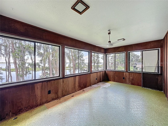 11401 Cypress Dr, Clermont, FL 34711 - unfurnished sunroom with wooden walls, a textured ceiling, and a water view