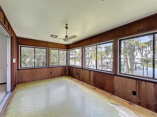 11401 Cypress Dr, Clermont, FL 34711 - unfurnished sunroom featuring healthy amount of natural light, a textured ceiling, and wooden walls