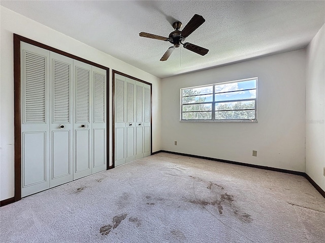 11401 Cypress Dr, Clermont, FL 34711 - unfurnished bedroom with two closets, carpet flooring, a textured ceiling, and a ceiling fan