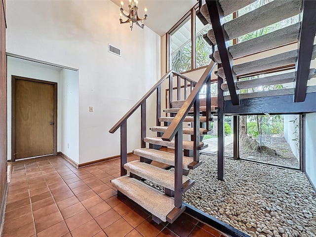 11401 Cypress Dr, Clermont, FL 34711 - staircase with tile patterned floors, high vaulted ceiling, and a chandelier