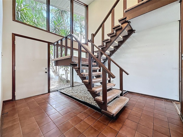 11401 Cypress Dr, Clermont, FL 34711 - foyer entrance featuring dark tile patterned flooring, stairs, and a high ceiling