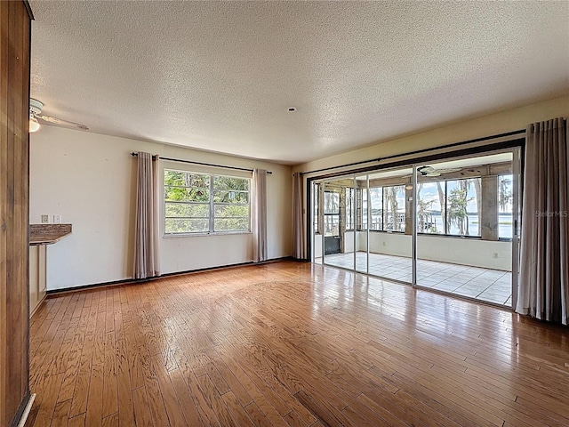 11401 Cypress Dr, Clermont, FL 34711 - spare room with a textured ceiling, wood-type flooring, and a ceiling fan
