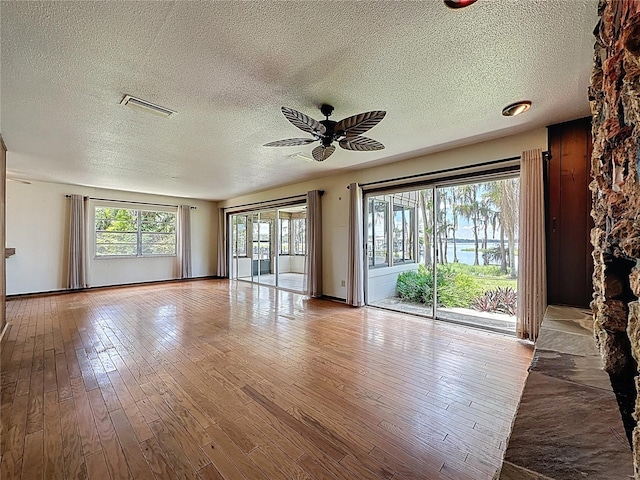 11401 Cypress Dr, Clermont, FL 34711 - unfurnished living room featuring a ceiling fan, a textured ceiling, and hardwood / wood-style floors