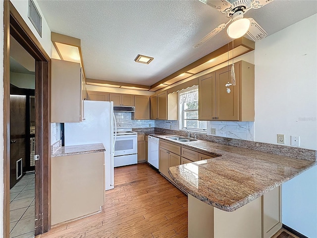 11401 Cypress Dr, Clermont, FL 34711 - kitchen featuring white appliances, a peninsula, ceiling fan, ventilation hood, and backsplash
